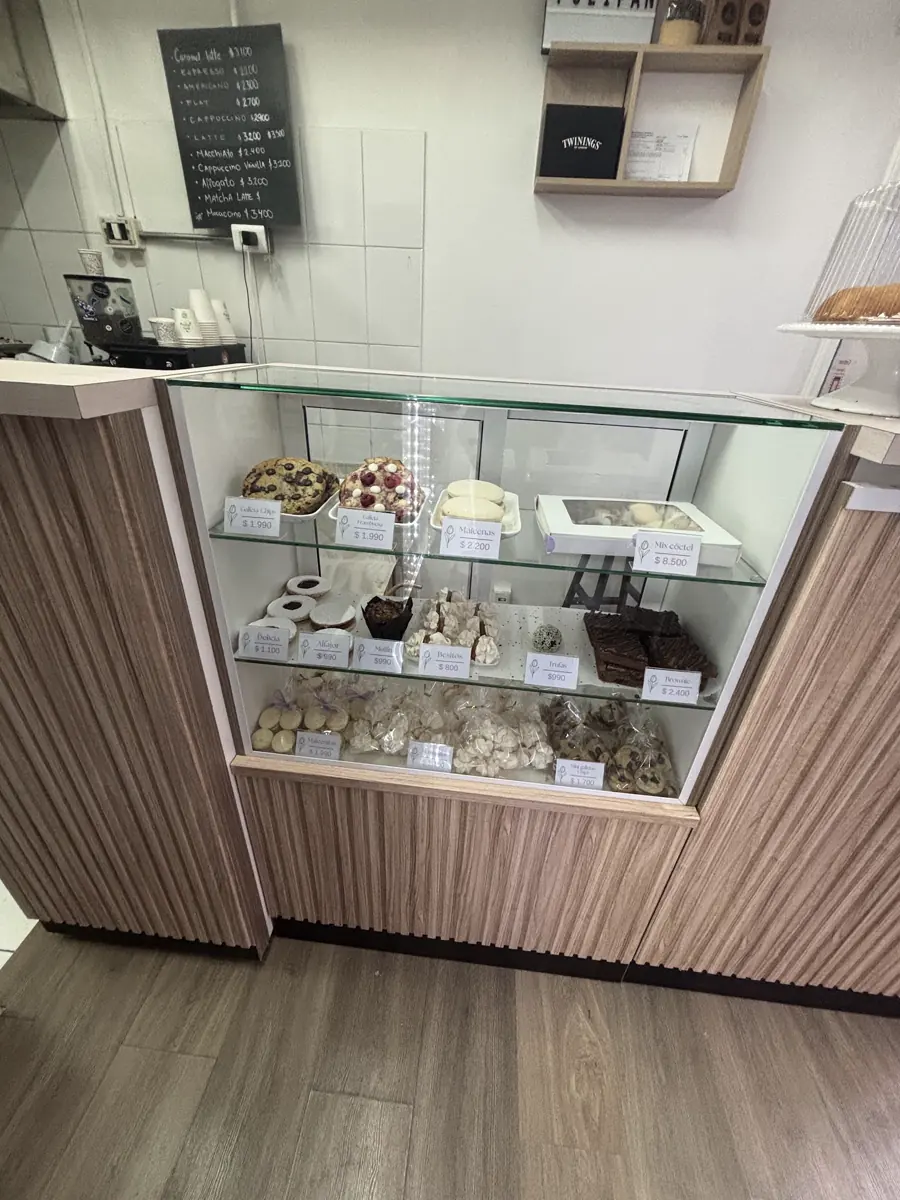 Mesón de madera clara con la vitrina refrigerada y la pizarra al fondo