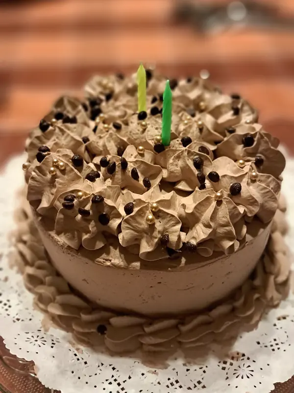 Torta de cumpleaños de chocolate con crema y dos velas